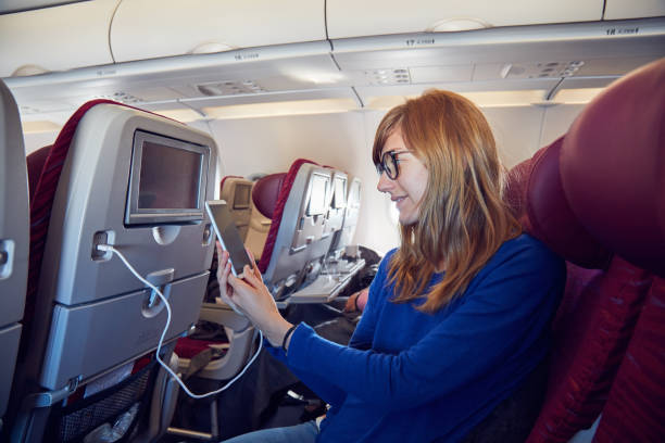istock Woman using cellphone in modern airplane seat. 1166164879