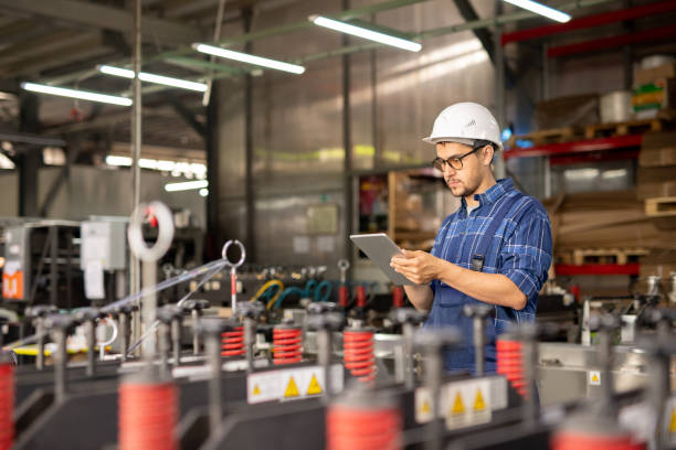 istock Young busy engineer in hardhat and workwear searching for data in the net 1166165008