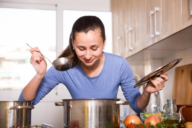 istock Housewife tasting soup at kitchen 1166166182