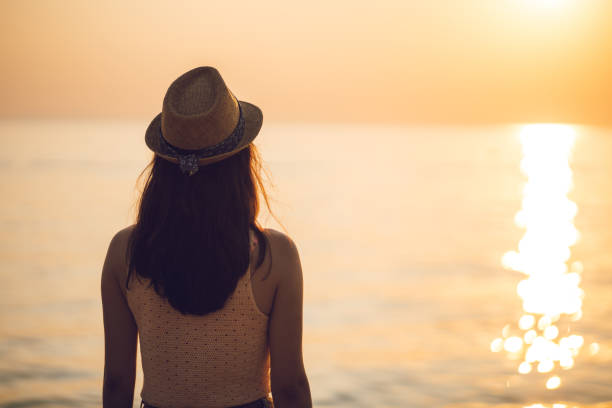 istock Woman watching sunset at beach 1166166285
