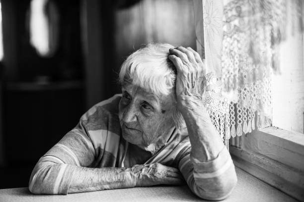 uma mulher idosa na mesa em casa. retrato preto e branco do close-up. - 16192 - fotografias e filmes do acervo