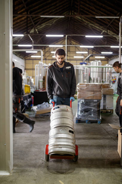 istock Brewer in storage room pushing cart with kegs 1166167928