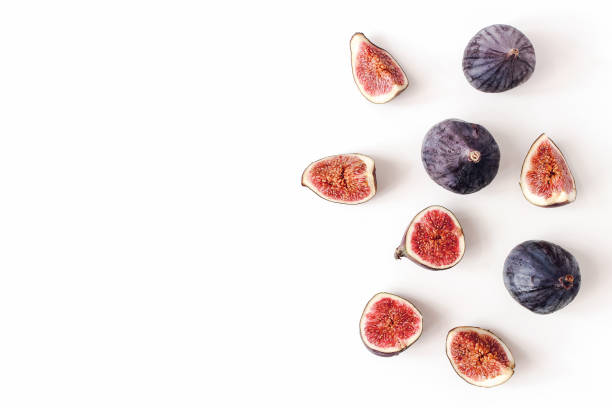 istock Fresh ripened purple figs. Creative composition, decorative banner of whole and sliced exotic fruit isolated on white table background. Natural pattern. Flat lay, top view. Food photography. 1166168735