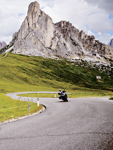 Biker Riding on Mountain Road in European Alps