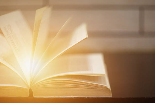 istock Light coming from book on wooden background. 1166170948