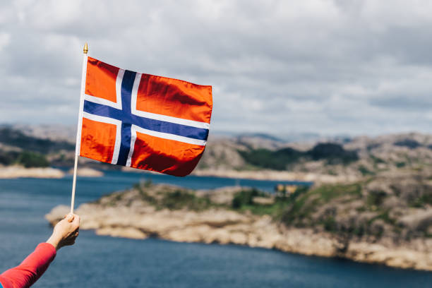 istock Tourist with norwegian flag on sea coast 1166171432