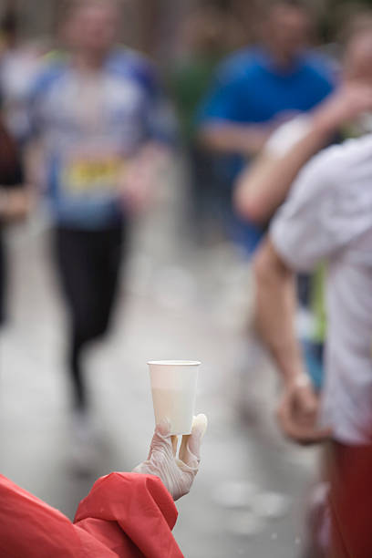 istock offering drink to running athletes 116617221