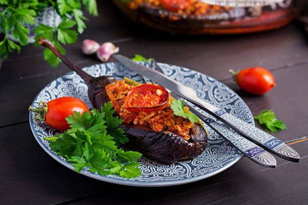 Karniyarik - turkish traditional aubergine eggplant meal. Stuffed eggplants with ground beef and vegetables baked with tomato sauce. Turkish cuisine. stock photo