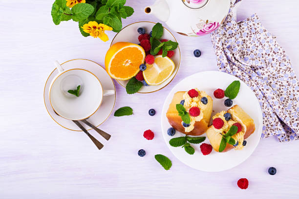 istock Rum baba decorated with whipped cream and fresh raspberry, blueberry. Savarin with rum, cream and berries. Italian cuisine. Top view 1166172804