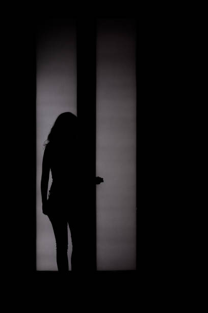 istock Woman silhouette in front of back-lighted door 1166172900