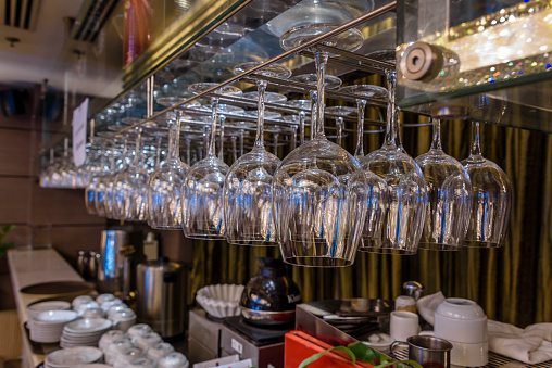 Wine glasses hang above the bar in a hotel.