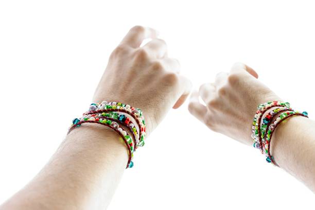 istock Cropped Hands Of People With Bracelets Against White Background 1166176264