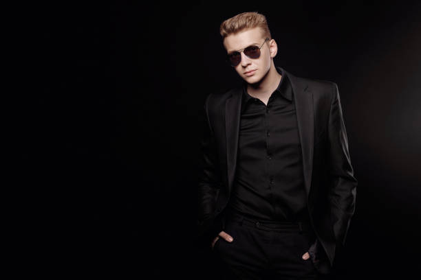 istock young man with black glasses in black jacket on black background 1166176808