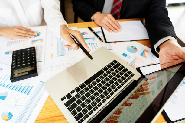 istock Midsection Of Business People Working At Table 1166177199