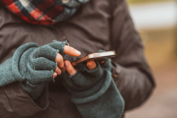 istock Midsection Of Woman Using Smart Phone During Winter 1166177993