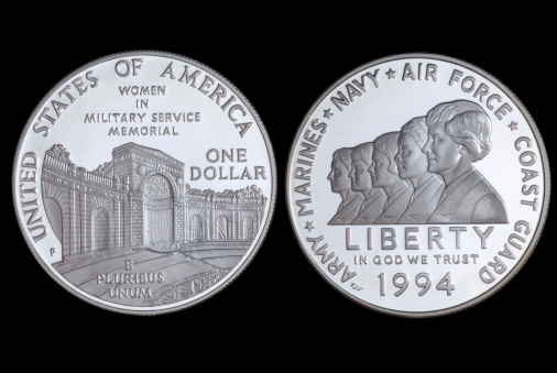 Silver coins of American currency isolated with black background.