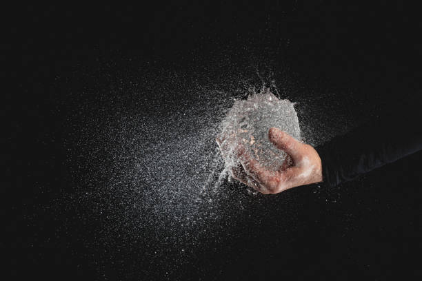 istock Cropped Hand Of Man Exploding Balloon Against Black Background 1166179785