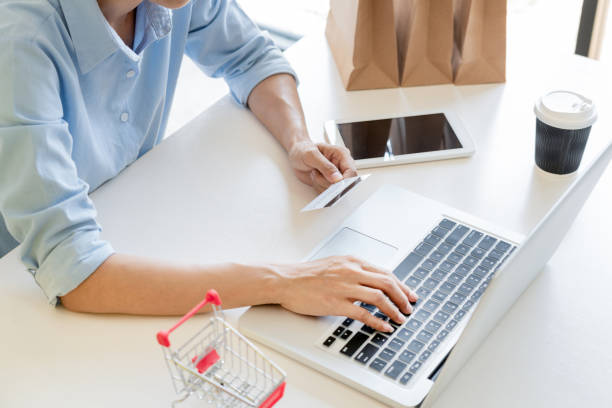 istock Midsection Of Person Using Laptop While Holding Credit Card On Table 1166179918