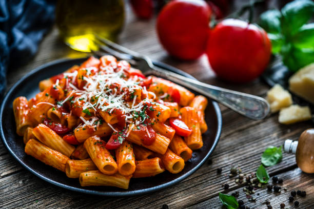istock Rigatoni pasta with tomato sauce shot on rustic wooden table 1166182062