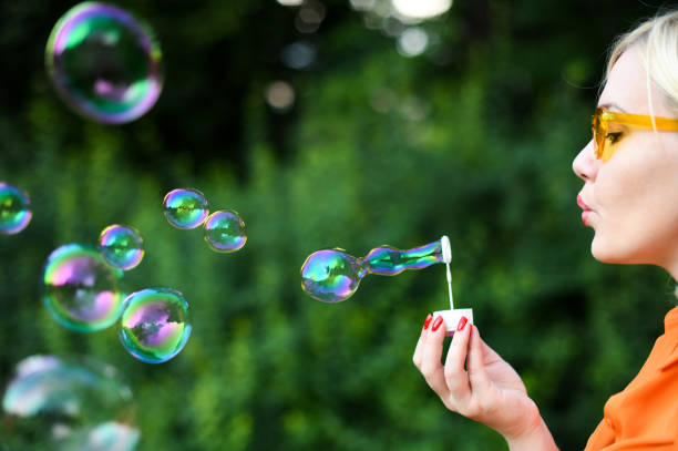 istock Blond girl blowing bubbles outdoor 1166182128