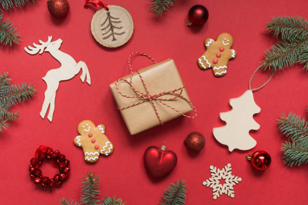 istock Christmas present, handmade gift boxes, wooden diy decor , evergreen branches, gingerbread cookies on red paper. View from above, flat lay. Xmas holiday. Template, mockup, greeting New Year card. 1166184562