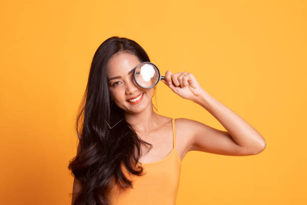 istock Young Asian woman with a magnifying glass. 1166185255