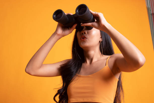 istock Young Asian woman with binoculars. 1166185430