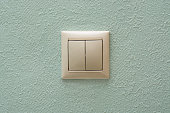light switch, a white plastic mechanical switch on blue wall.