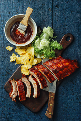 Grilled pork ribs with barbecue sauce on wooden background