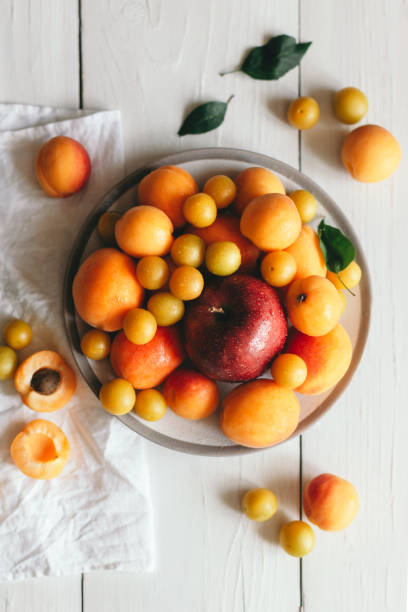 istock Apple, apricots and cherry-plums on a white plate. 1166191171