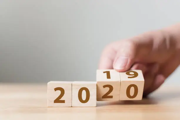 Photo of New year 2019 change to 2020 concept. Hand flip over wood cube block
