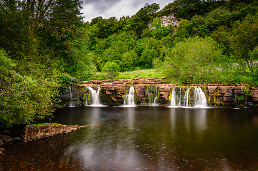 Wain Wath Force is a waterfall situated on the River Swale in the Yorkshire Dales National Park and flows beneath the limestone cliffs of Cotterby Scar