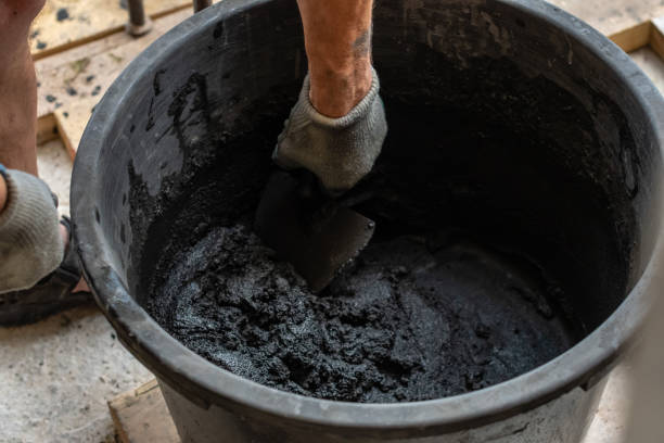 istock Mans hand hold a trowel and mixed cement in bucket. 1166196779