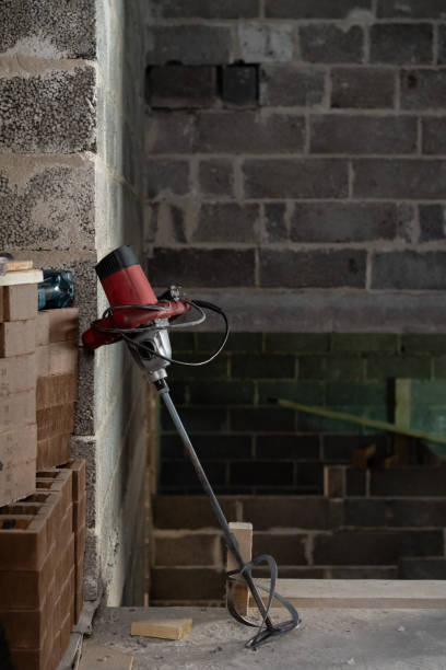 electric drill with a mixer in a newly constructed building. - drill red work tool power imagens e fotografias de stock