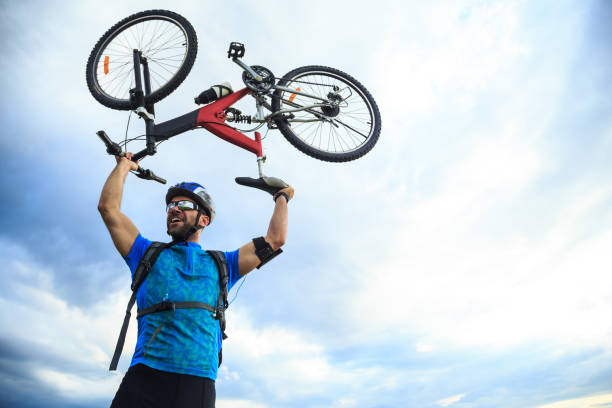 istock Cheerful biker lifting up his bike 1166198140