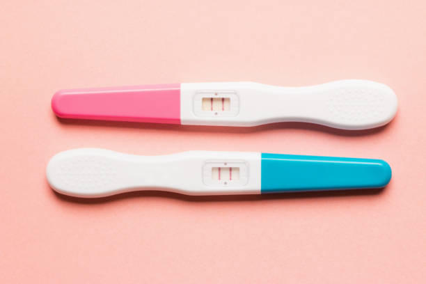 istock Positive pink and blue plastic pregnancy test on pink background 1166198701