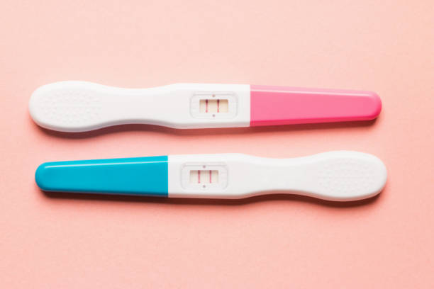 istock Positive pink and blue plastic pregnancy test on pink background 1166198820