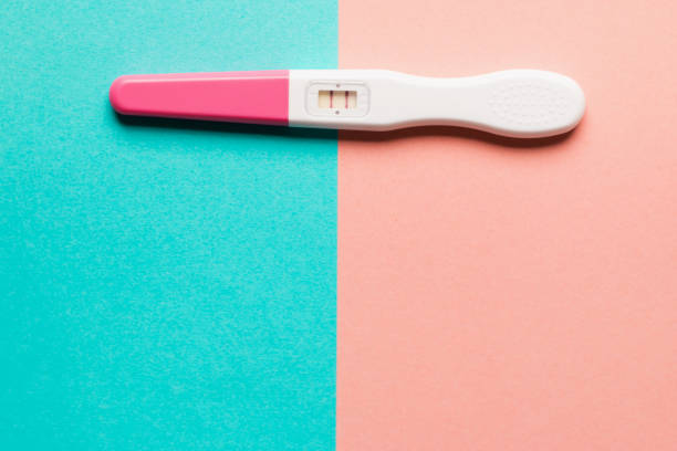 istock Positive pink plastic pregnancy test on pink and blue background 1166198826