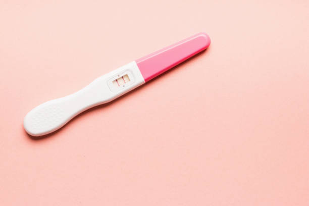 istock Positive pink plastic pregnancy test on pink background. 1166198924