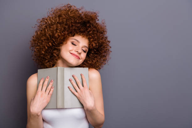 close up photo of lady reader hold favorite novel close eyes closed overjoyed wear white tank-top isolated grey background - silence curly hair facial expression female imagens e fotografias de stock