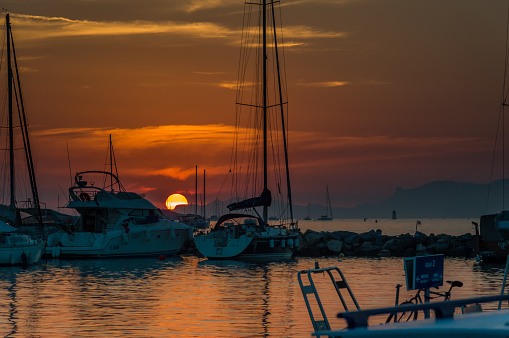 Marsaxlokk, Malta - November, 2018: Red sunset in the harbour of Marsaxlokk, picture taken from the beach.