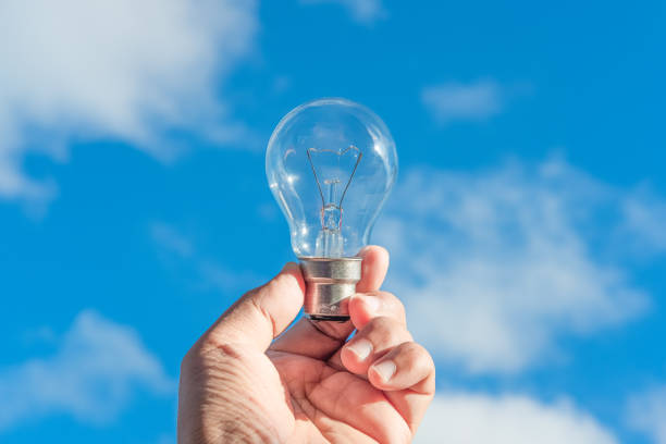 istock hand holding light bulb and blue sky background 1166202653