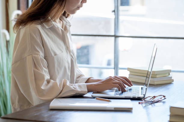 istock The hand of a young woman working at remote work 1166202696
