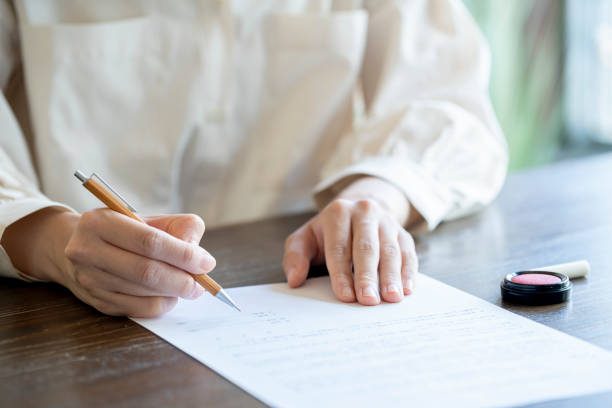 istock Young woman writing papers on a desk 1166203000