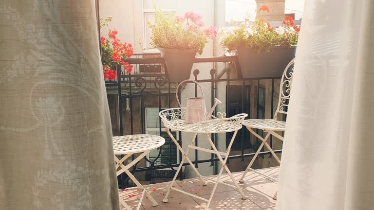 small romantic balcony with flower boxes and curtains blowing in the wind