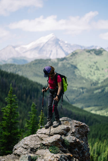 istock Female hiker on an adventure stands on a platform on a mountain looking out 1166204293