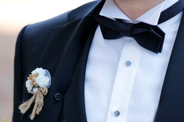 Close up of a mans formal tuxedo shirt. Tie is in sharp focus. Foreground buttons blur with dof.