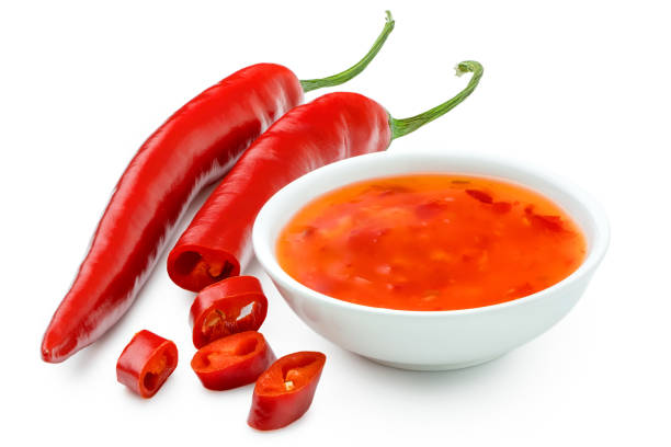 istock Sweet chilli sauce in a white ceramic bowl next to one whole and one cut red chilli isolated on white. 1166209292