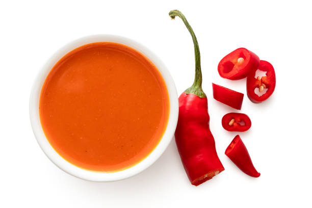 peri peri chilli sauce in a white ceramic bowl next to a cut up chilli pepper isolated on white from above. - birds eye chilli imagens e fotografias de stock