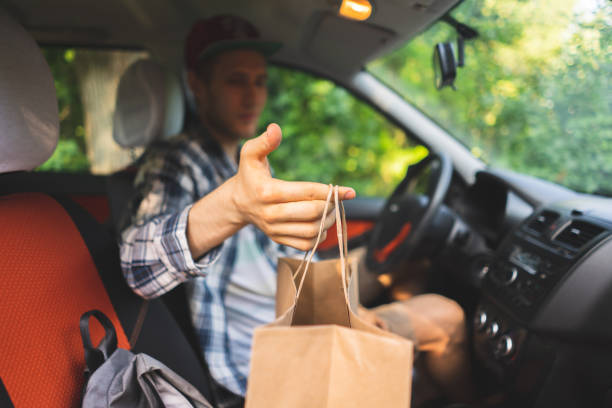 istock courier sit inside the car and move to the client to give the package 1166209591
